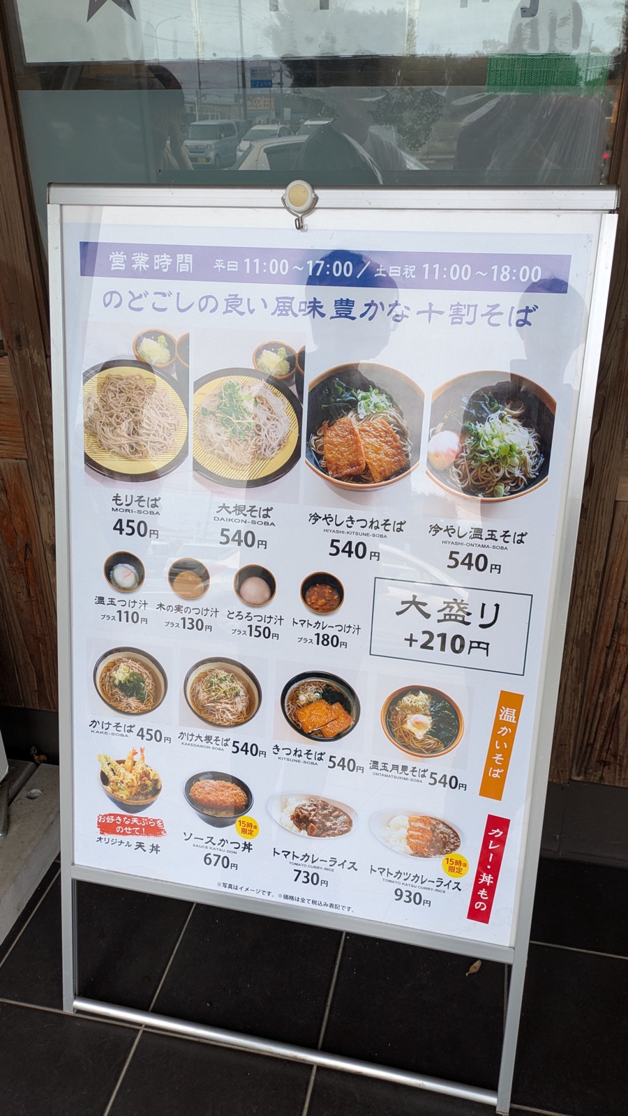 もりそば450円、大根そば540円などを写真付きで並べたメニューと営業時間を載せたA型看板