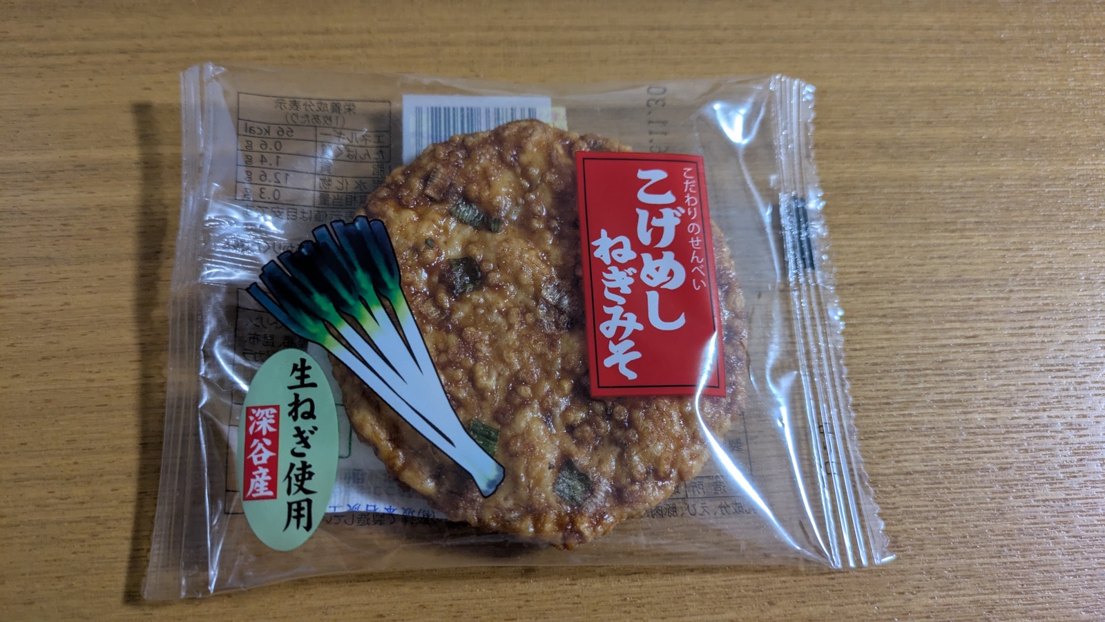 「こげめし ねぎみそ」と書かれた個包装のせんべい。袋にねぎのイラストと「深谷産 生ねぎ使用」の表示がある