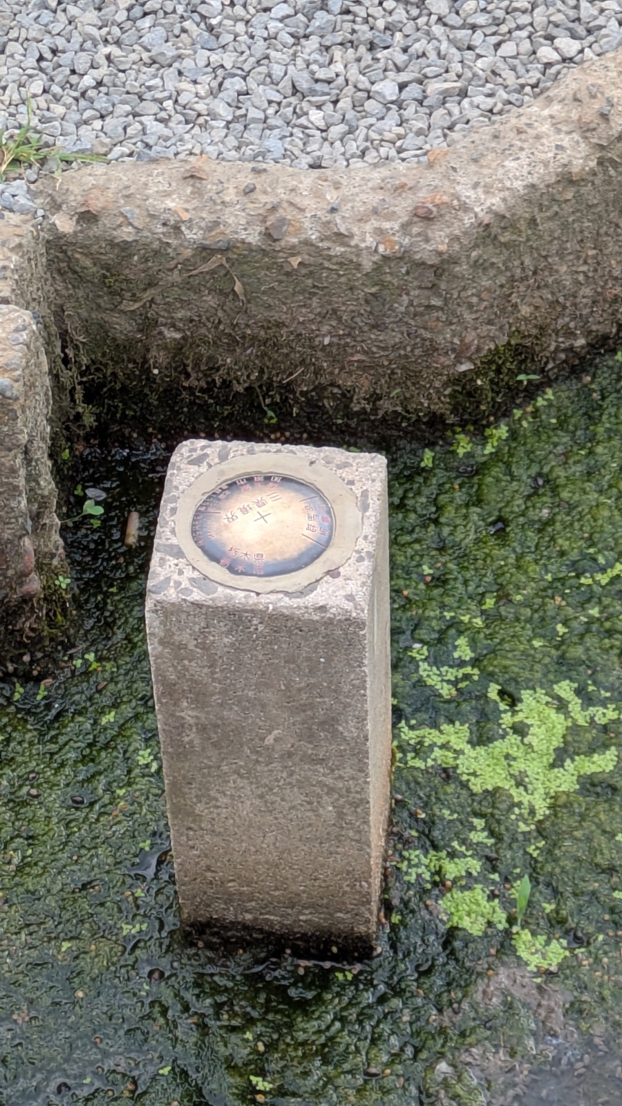 水路の合流点に立つ「三県境」と刻まれた石柱