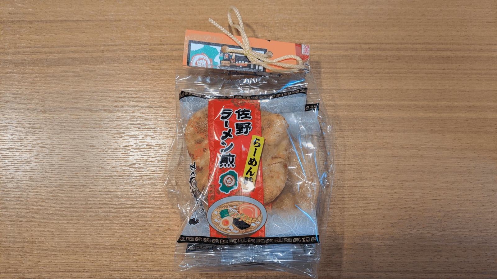 「佐野ラーメン煎 らーめん味」のラベルが貼られた透明な袋入りのせんべい