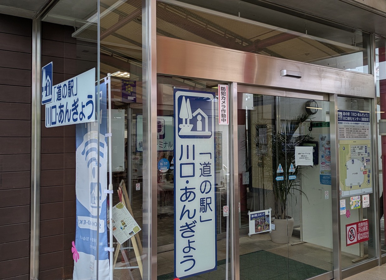 ガラス張りの正面入口。自動ドアの横に「「道の駅」川口・あんぎょう」と書かれた縦長の看板と横長の看板が掲げられている