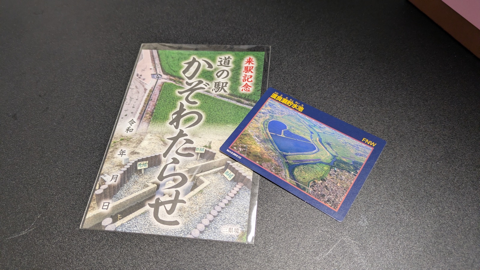 「渡良瀬貯水池」と書かれたダムカードと、道の駅かぞわたらせの来駅記念カード