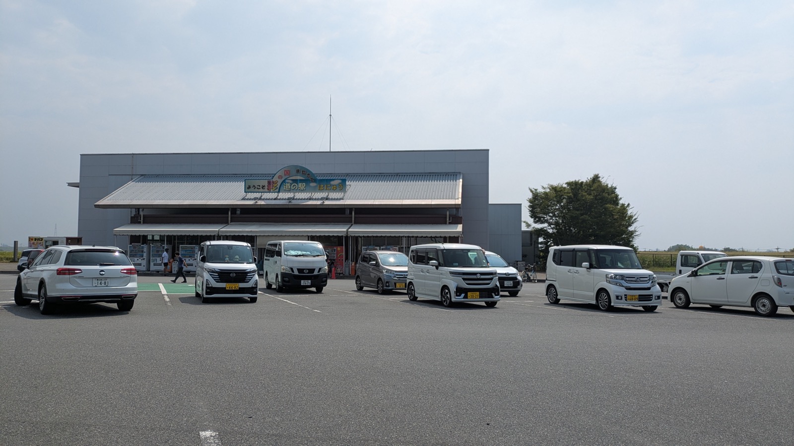 「ようこそ 道の駅 はにゅう」の看板を掲げた平屋の建物と、手前に広がる駐車場