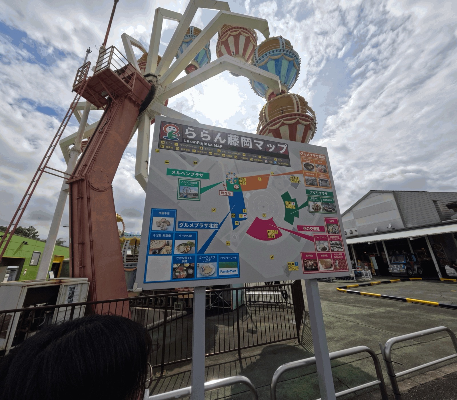 観覧車の前に立つ「ららん藤岡マップ」の案内板。メルヘンプラザ・グルメプラザ北館・南館・アグリプラザ・花の交流館の位置と、各店舗の写真が載っている